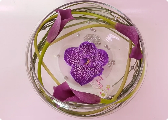 Centre de table avec callas prunes ,vanda violette et perles